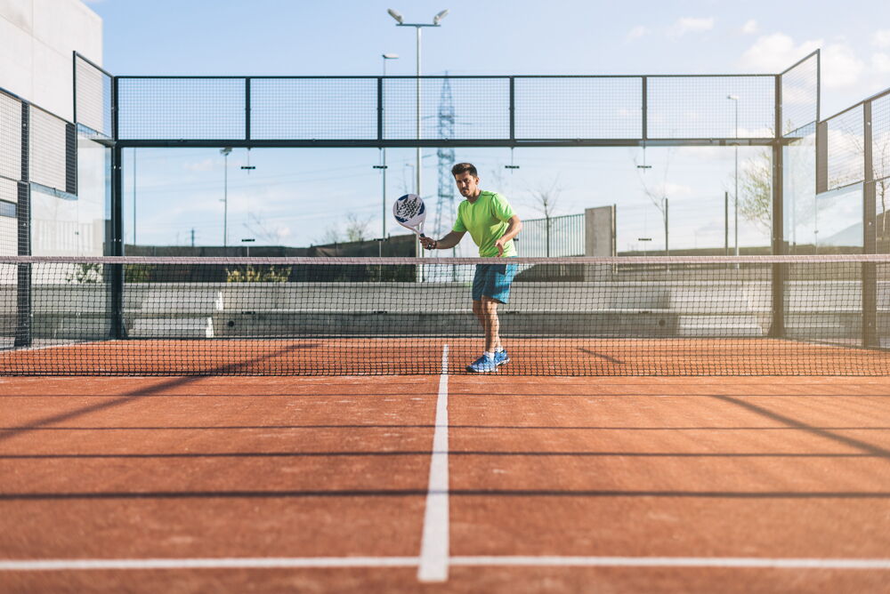 Padel player on red turf field